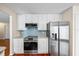 Bright kitchen features stainless steel appliances, blue backsplash, and white cabinetry at 400 Westborough Ln, Safety Harbor, FL 34695