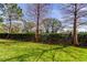 View of the backyard showcasing the green lawn and privacy hedge at 4676 66Th N Pl, Pinellas Park, FL 33781