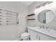Modern bathroom with a sleek vanity, stylish fixtures, open shelving, and heated towel rack at 4812 Wynwood Dr, Tampa, FL 33615