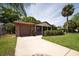 Beautifully maintained single-story brick home with a manicured lawn, a front patio and attached garage at 4812 Wynwood Dr, Tampa, FL 33615