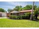 Charming single-story home with a manicured lawn, mature landscaping, and brick accents at 4812 Wynwood Dr, Tampa, FL 33615