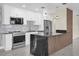 Modern kitchen featuring stainless steel appliances, marble backsplash and a black marble waterfall island at 4812 Wynwood Dr, Tampa, FL 33615