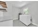 Bright laundry room with washer, dryer, utility sink and open shelving at 4812 Wynwood Dr, Tampa, FL 33615
