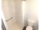 Bathroom featuring a shower, toilet, hand bar, and plastic shower curtain at 5244 Betty St, Zephyrhills, FL 33542