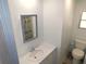 Bathroom with a sink, framed mirror, and toilet, providing a functional and clean space at 5244 Betty St, Zephyrhills, FL 33542