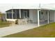 Charming mobile home featuring a screened porch and covered parking with a well-maintained lawn at 5244 Betty St, Zephyrhills, FL 33542