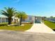 Charming single-story home with well-manicured lawn, mature palm trees, and convenient carport at 5244 Betty St, Zephyrhills, FL 33542