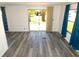 Spacious living room with laminate flooring and large sliding doors leading to outdoor greenery at 5244 Betty St, Zephyrhills, FL 33542