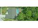 Aerial view of the property with a screened-in pool surrounded by lush greenery at 5343 Sagamore Ct, New Port Richey, FL 34655