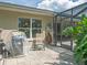 Outdoor patio area featuring a grill, seating, and easy access to the screened-in pool area at 5343 Sagamore Ct, New Port Richey, FL 34655