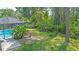 View of a backyard with lush greenery, trees, and a section of the screened-in pool at 5343 Sagamore Ct, New Port Richey, FL 34655