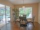 Dining area with glass table, wicker chairs, and sliding door to the screened-in lanai and pool at 5343 Sagamore Ct, New Port Richey, FL 34655
