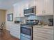 Modern kitchen with white cabinets, stainless steel appliances, and stylish backsplash at 5343 Sagamore Ct, New Port Richey, FL 34655