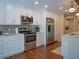 Bright kitchen featuring white cabinetry, stainless steel appliances, and hardwood floors at 5343 Sagamore Ct, New Port Richey, FL 34655