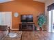 Well-lit living room showcasing hardwood floors, a TV, and a view of the outdoor space with greenery at 5343 Sagamore Ct, New Port Richey, FL 34655