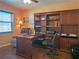 Home office with a large desk, chair, built-in shelving, and natural light from the window at 5343 Sagamore Ct, New Port Richey, FL 34655