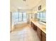 A luxurious bathroom featuring dual sinks, a soaking tub, and a glass-enclosed shower at 5525 Thorngrove Way, Spring Hill, FL 34609