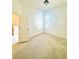 Bright bedroom with neutral carpet, two windows, and white walls at 5525 Thorngrove Way, Spring Hill, FL 34609