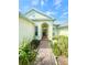 Inviting entryway with a brick path surrounded by lush landscaping leading to the front door at 5525 Thorngrove Way, Spring Hill, FL 34609