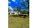 Exterior view of the home with a lush green lawn and mature trees at 5525 Thorngrove Way, Spring Hill, FL 34609