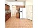 Open kitchen features wooden cabinets, a refrigerator, and tile flooring at 5525 Thorngrove Way, Spring Hill, FL 34609