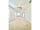 A cozy living room with beige carpeting, ceiling fan and a glass panel door at 5525 Thorngrove Way, Spring Hill, FL 34609