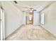An open living room with carpeted flooring, a ceiling fan and bright white walls at 5525 Thorngrove Way, Spring Hill, FL 34609