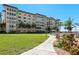 Exterior view of a condominium building with well-maintained landscaping, swimming pool, and sidewalk at 620 Edgewater Dr # 501, Dunedin, FL 34698