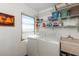 Well-lit laundry room equipped with a washer, dryer, and storage shelves at 620 Edgewater Dr # 501, Dunedin, FL 34698