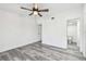 Bright bedroom boasts gray wood-look floors and ceiling fan with bathroom access at 6343 92Nd N Pl # 2102, Pinellas Park, FL 33782