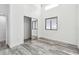 Bright bedroom featuring gray wood-look flooring, closet with mirrored doors, and natural light from two windows at 6343 92Nd N Pl # 2102, Pinellas Park, FL 33782
