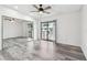 Light-filled bedroom boasts gray wood-look floors, closet with mirrored doors, ceiling fan and access to the balcony at 6343 92Nd N Pl # 2102, Pinellas Park, FL 33782