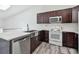 Contemporary kitchen featuring stainless appliances, granite countertops, and dark wood cabinets at 6343 92Nd N Pl # 2102, Pinellas Park, FL 33782