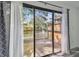 View of the wooden patio through a sliding door with white curtains and grey patterned drapes at 6343 92Nd N Pl # 2102, Pinellas Park, FL 33782
