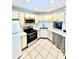 Bright kitchen featuring white cabinets, stainless steel appliances, and checkered curtain at 717 Cordova Green, Seminole, FL 33777