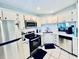Well-equipped kitchen with white cabinets, stainless steel appliances, and ample counter space at 717 Cordova Green, Seminole, FL 33777