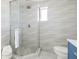 Modern bathroom features a glass-enclosed shower with decorative tiled walls at 728 Pruitt Dr, Madeira Beach, FL 33708
