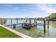 Dock featuring boat lift, boat dock and ramp leading into the water at 728 Pruitt Dr, Madeira Beach, FL 33708