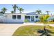 Charming single-story home with a modern design, well-maintained lawn, and palm trees at 728 Pruitt Dr, Madeira Beach, FL 33708