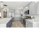 Bright kitchen with stainless steel appliances, gray cabinets, and quartz countertops at 728 Pruitt Dr, Madeira Beach, FL 33708
