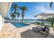 Waterfront home with a private pool, sun loungers, and dock on a sunny day at 728 Pruitt Dr, Madeira Beach, FL 33708