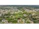An aerial view showcases a neighborhood with homes nestled among mature trees along a waterway at 8425 Jackson Springs Rd, Tampa, FL 33615