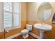 Charming bathroom with a pedestal sink, hardwood floors, and lots of natural light at 8425 Jackson Springs Rd, Tampa, FL 33615