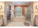 Elegant bathroom featuring a soaking tub with tile surround and a glass-enclosed shower at 8425 Jackson Springs Rd, Tampa, FL 33615