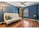 Themed room with blue walls, wood floors, ceiling fan, and futon couch at 8425 Jackson Springs Rd, Tampa, FL 33615