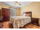Cozy bedroom with hardwood floors, a ceiling fan, and a charming quilt-covered bed at 8425 Jackson Springs Rd, Tampa, FL 33615