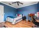 Inviting bedroom features a ceiling fan, hardwood floors, and blue color scheme at 8425 Jackson Springs Rd, Tampa, FL 33615