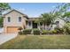 Charming two-story home with landscaped yard, inviting front porch, and attached garage offering ample curb appeal at 8425 Jackson Springs Rd, Tampa, FL 33615