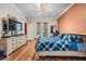 Spacious main bedroom with hardwood floors, dresser, TV, and access to the outdoors at 8425 Jackson Springs Rd, Tampa, FL 33615
