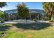 Screened-in patio with green grass and tropical landscaping offering a relaxing outdoor space at 1038 Emerald Dunes Dr, Sun City Center, FL 33573